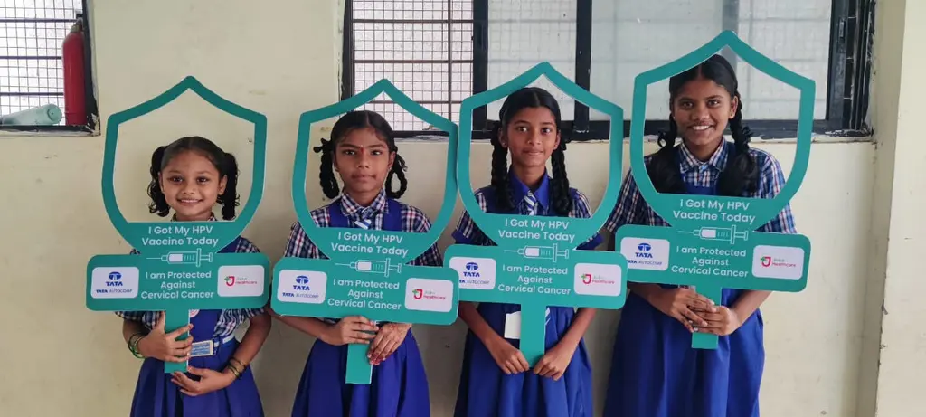 Schoolgirls holding HPV protection photo frames after vaccination