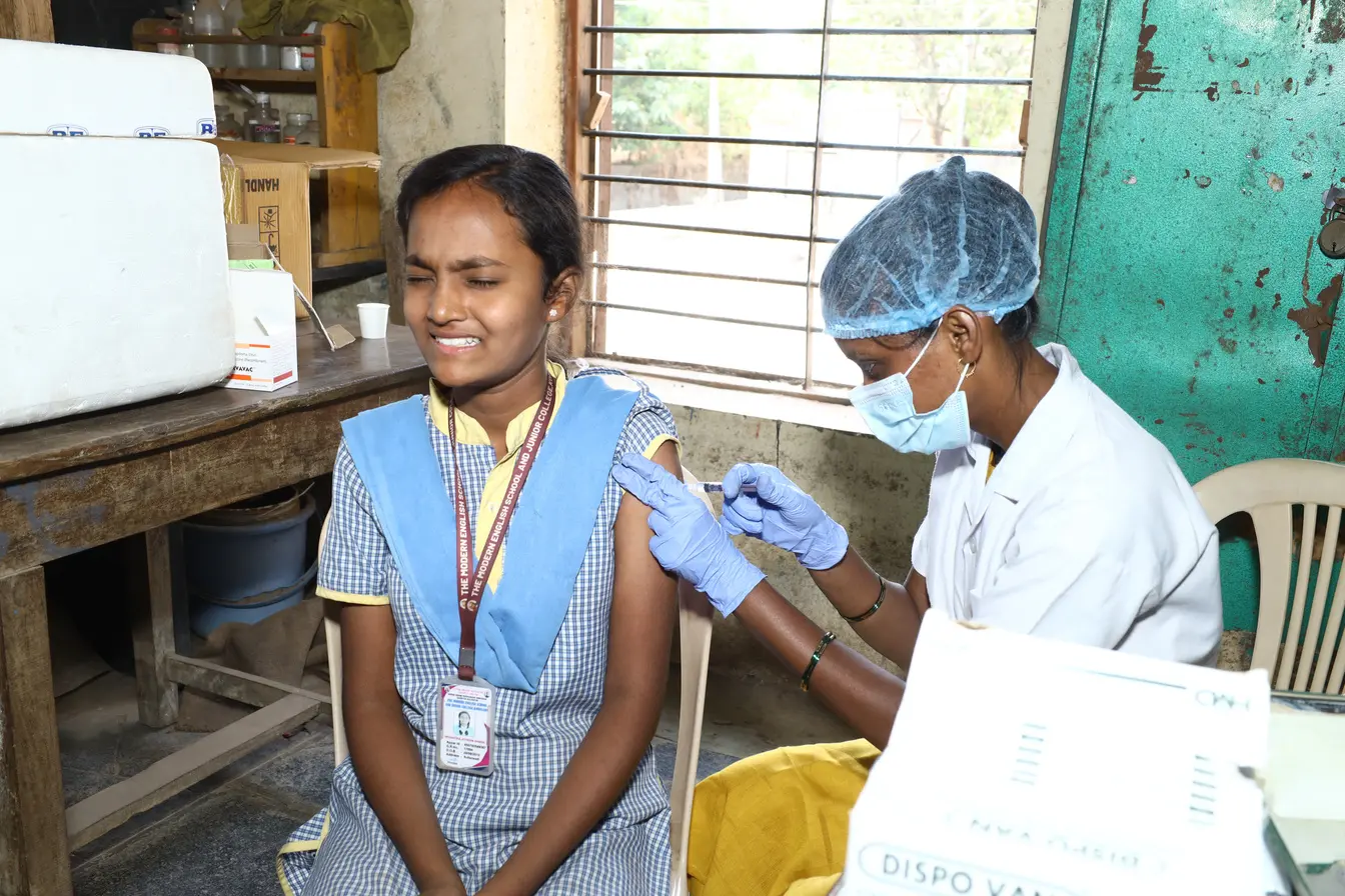 A healthcare professional administering an HPV vaccination at school